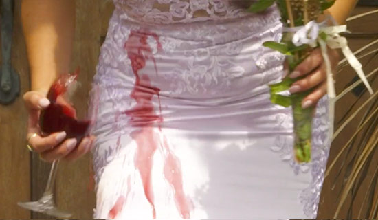 Woman spilling wine on her wedding dress