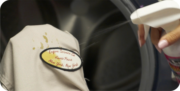 Spraying stain on work shirt